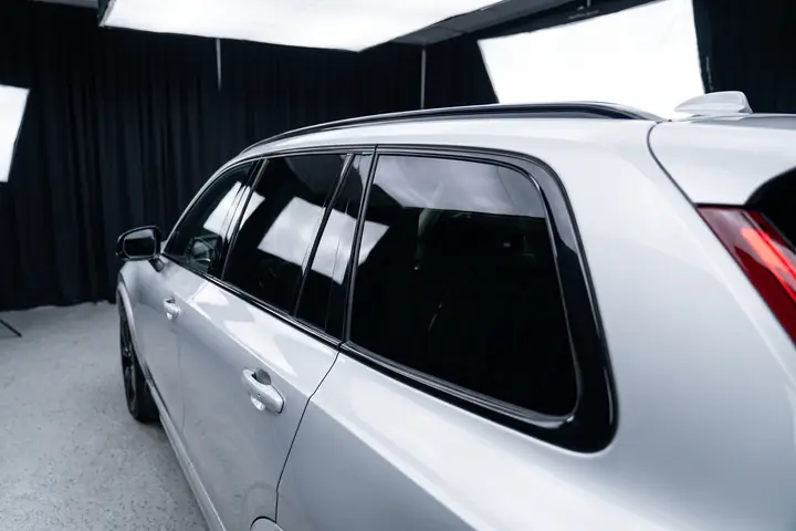 Volvo XC90 prata num estúdio, com os vidros em grafite neutro, sem tom arroxeado