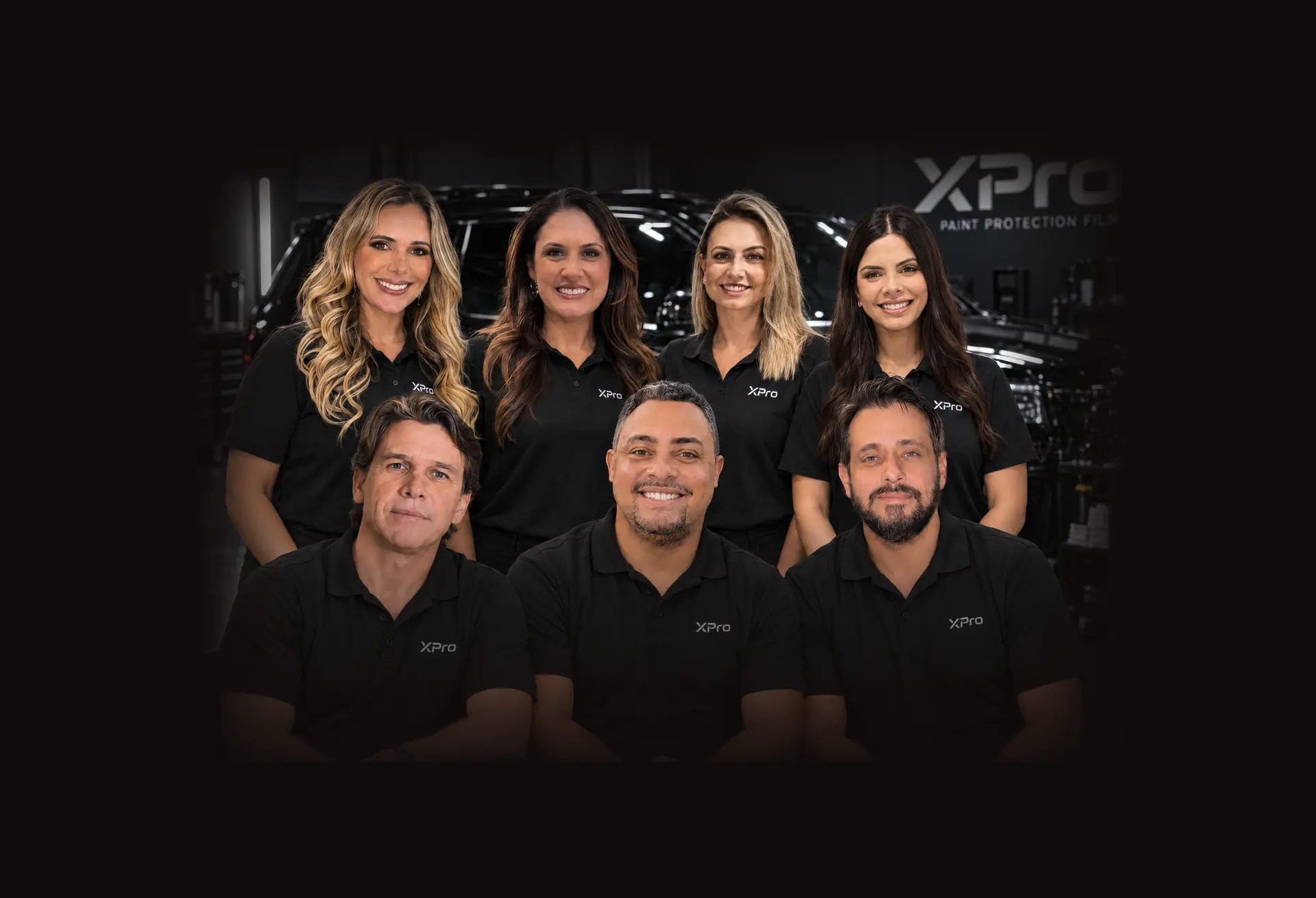 Equipe Segvel / XPro de polo preta da XPro em um estúdio de estética automotiva